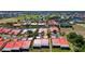 Aerial view of community residences with red tile roofs and a golf course and lake in the distance at 1780 Deborah Dr # 25, Punta Gorda, FL 33950