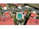 Aerial view of a community pool surrounded by tropical landscaping and homes with red roofs at 1780 Deborah Dr # 25, Punta Gorda, FL 33950