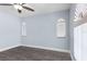 Bedroom with light blue walls, ceiling fan, arched windows, and wood look flooring at 1780 Deborah Dr # 25, Punta Gorda, FL 33950