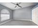 Bedroom with light gray walls, gray floors, arched window, white trim, and double door closet at 1780 Deborah Dr # 25, Punta Gorda, FL 33950
