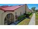 Charming home featuring a red metal roof, manicured landscaping, and inviting entrance at 1780 Deborah Dr # 25, Punta Gorda, FL 33950