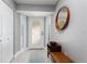 Bright foyer with a decorative front door, light wood floors, and a stylish round mirror at 1780 Deborah Dr # 25, Punta Gorda, FL 33950