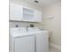 Bright laundry room featuring a washer, dryer, and white cabinets for ample storage space at 1780 Deborah Dr # 25, Punta Gorda, FL 33950