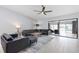 An inviting living room with a large black leather couch, ceiling fan, and sliding glass doors at 1780 Deborah Dr # 25, Punta Gorda, FL 33950