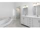Bright bathroom with double vanities, a soaking tub, and a glass-enclosed shower at 1780 Deborah Dr # 25, Punta Gorda, FL 33950