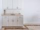 Sunroom wet bar with white cabinets, tile floors, and lots of storage space at 1780 Deborah Dr # 25, Punta Gorda, FL 33950