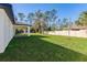 Expansive backyard featuring a well-maintained lawn, white fence, and covered patio at 18124 Goliad Ave, Port Charlotte, FL 33954