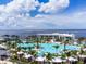 An expansive resort-style pool surrounded by palm trees and a bay view offers a luxurious place to relax at 21194 Edgewater Dr, Port Charlotte, FL 33952