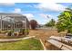 Landscaped backyard featuring a screened pool area, gravel, and lush greenery at 21194 Edgewater Dr, Port Charlotte, FL 33952