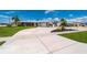 Charming single-story home with a metal roof, wide driveway, and lush landscaping under a sunny blue sky at 21194 Edgewater Dr, Port Charlotte, FL 33952