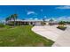 Charming single-story home with a metal roof, a wide driveway, and lush landscaping under a sunny blue sky at 21194 Edgewater Dr, Port Charlotte, FL 33952