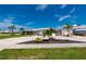 Charming single-story home with a metal roof, detached garage, boat, and lush landscaping under a sunny blue sky at 21194 Edgewater Dr, Port Charlotte, FL 33952