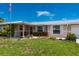 Single Gathering home with a manicured lawn, mature flower bed and an American flag in the front yard at 21194 Edgewater Dr, Port Charlotte, FL 33952