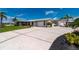 Single Gathering home with a circular driveway, lush lawn, and mature landscaping at 21194 Edgewater Dr, Port Charlotte, FL 33952