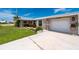 Single Gathering home featuring an attached garage, manicured lawn, and mature landscaping at 21194 Edgewater Dr, Port Charlotte, FL 33952