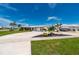 Single Gathering home with a circular driveway, lush lawn, and mature tropical landscaping at 21194 Edgewater Dr, Port Charlotte, FL 33952