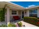 Cozy front porch with a red bench, mature flower bed and seating area at 21194 Edgewater Dr, Port Charlotte, FL 33952
