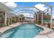 Beautiful screened-in pool area featuring comfortable seating and well-maintained landscaping at 21194 Edgewater Dr, Port Charlotte, FL 33952