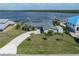 Expansive aerial view of a waterfront property, featuring lush landscaping and a private dock against a serene water backdrop at 2308 Harbour Dr, Punta Gorda, FL 33983