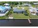 Aerial view displays a waterfront home with a dock, enclosed lanai and mature landscaping at 2308 Harbour Dr, Punta Gorda, FL 33983