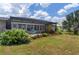 Back patio with a screen enclosure, plush seating, and vibrant landscaping at 2308 Harbour Dr, Punta Gorda, FL 33983