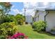 Landscaped backyard with colorful flowers, tropical greenery, and a storage shed at 2308 Harbour Dr, Punta Gorda, FL 33983