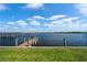 A waterfront dock extends into the open water, set against a clear sky and calm horizon at 2308 Harbour Dr, Punta Gorda, FL 33983