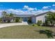 Welcoming single-story home with a lush front yard, complemented by mature landscaping and blue front doors at 2308 Harbour Dr, Punta Gorda, FL 33983