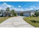 Charming single-story home featuring lush landscaping, a two-car garage, and a concrete driveway under a bright sky at 2308 Harbour Dr, Punta Gorda, FL 33983