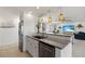 Modern kitchen featuring an island with a sink, complemented by stainless steel appliances, and pendant lighting at 2308 Harbour Dr, Punta Gorda, FL 33983