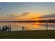 Stunning water view at sunset with reflections on the water, dock and grassy foreground at 2308 Harbour Dr, Punta Gorda, FL 33983