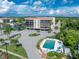 Aerial view of condo building, pool, and waterfront, showcasing community amenities at 25188 Marion Ave # E409, Punta Gorda, FL 33950