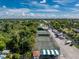 Overhead shot of two tennis courts with surrounding tropical trees, lush green landscape, and boat parking at 25188 Marion Ave # E409, Punta Gorda, FL 33950