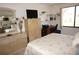 Cozy bedroom features a TV, dresser, and a sunny window view to the outside at 25188 Marion Ave # F106, Punta Gorda, FL 33950