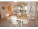 Bright dining room with marble table, white chairs, and mirrored display cabinet with artwork at 25188 Marion Ave # F106, Punta Gorda, FL 33950