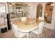 Elegant dining room with beige marble table, upholstered chairs, and mirrored display case at 25188 Marion Ave # F106, Punta Gorda, FL 33950