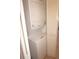 Efficient laundry area features a stacked washer and dryer with white wooden shuttered doors at 25188 Marion Ave # F106, Punta Gorda, FL 33950
