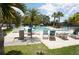 Resort-style pool surrounded by palm trees and lounge chairs, offering a relaxing oasis for residents at 25188 Marion Ave # F106, Punta Gorda, FL 33950