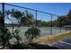 Outdoor tennis court surrounded by lush greenery, offering a recreational space for sports at 25188 Marion Ave # F106, Punta Gorda, FL 33950
