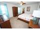 Comfortable bedroom featuring a ceiling fan, dresser and blue curtains, plus stylish furniture at 25325 E Lenox Cir, Punta Gorda, FL 33950