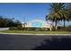 Waterford's welcoming community sign is surrounded by lush landscaping and tropical palm trees at 25325 E Lenox Cir, Punta Gorda, FL 33950