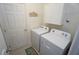 Well-lit laundry room with a modern washer and dryer, storage cabinets and unique decorations at 25325 E Lenox Cir, Punta Gorda, FL 33950