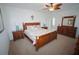 Bright main bedroom featuring wooden furniture set, ceiling fan, and carpet flooring at 25325 E Lenox Cir, Punta Gorda, FL 33950