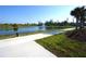 Relaxing waterfront views along the community walking path with lush landscaping and palm trees at 25325 E Lenox Cir, Punta Gorda, FL 33950