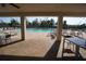 View of the community pool from the pavilion featuring comfortable lounge chairs and tables under tropical trees at 25325 E Lenox Cir, Punta Gorda, FL 33950