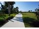 Stroll along the serene walking path lined with palm trees and lush landscaping at 25325 E Lenox Cir, Punta Gorda, FL 33950
