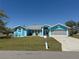 Charming blue single-story home featuring a well-manicured lawn and a gray roof with white trim at 25472 Tevesine Ct, Punta Gorda, FL 33983