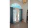 Inviting foyer featuring a tiled floor and double doors with decorative curtains at 25472 Tevesine Ct, Punta Gorda, FL 33983