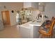 Open-concept kitchen with bar seating, gray cabinets, and tile flooring leads to a cozy dining area with pool view at 25472 Tevesine Ct, Punta Gorda, FL 33983