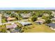 An aerial view showcasing a white home, a screened pool, and lush landscaping in a vibrant neighborhood at 25730 Deep Creek Blvd, Punta Gorda, FL 33983